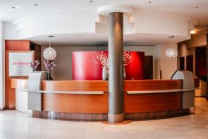 a lobby of a hotel with a reception desk at Leonardo Hotel Aachen in Aachen