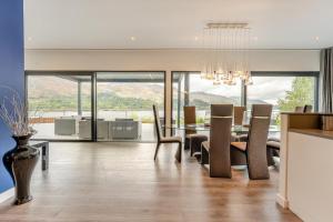 a dining room with a table and chairs and a kitchen at 5 Bed in St. Fillans oc-t30058 in Saint Fillans