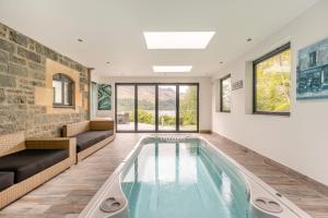 a swimming pool in a room with a couch and windows at 5 Bed in St. Fillans oc-t30058 in Saint Fillans