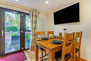 a dining room with a wooden table and a television at 1 Bed in Strathpeffer oc-h30077 in Strathpeffer +12 photos