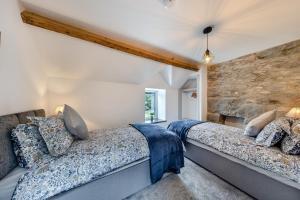 a bedroom with two beds and a stone wall at 2 Bed in Penmaenpool oc-m30050 in Arthog