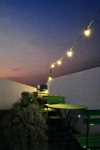 a table and chairs on a rooftop at night at Softbox Hostel in Ban Laem Thong Lang
