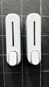 two white switches hanging on a tiled wall at Softbox Hostel in Ban Laem Thong Lang
