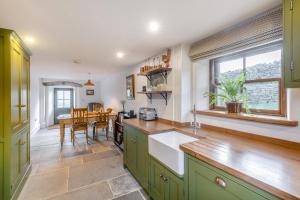 a kitchen with green cabinets and a dining room at 2 Bed in Cowling oc-l30774 in Cowling