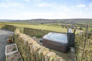 a hot tub on a stone wall with a view at 2 Bed in Cowling oc-l30774 in Cowling