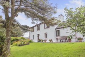 an exterior view of a white house with a yard at 3 Bed in Isle Of Skye oc-r31786 in Broadford