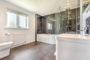 a bathroom with a tub and a toilet and a sink at 5 Bed in Bradworthy oc-d31987 in Bradworthy +32 photos