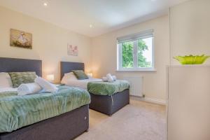 a bedroom with two beds and a window at 5 Bed in Bradworthy oc-d31987 in Bradworthy
