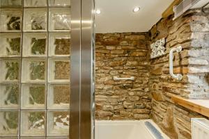 a bathroom with a stone wall and a bath tub at 2 Bed in Port Talbot oc-b30705 in Port Talbot +28 photos