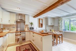 a large kitchen with white cabinets and a table at 3 Bed in Ilminster oc-b32054 in Barrington