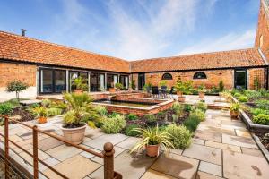 an outdoor garden with potted plants and a brick building at 2 Bed in Barton Turf oc-i29127 in Neatishead