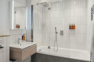 a white bathroom with a shower and a sink at Urban Rest Camden Town in London