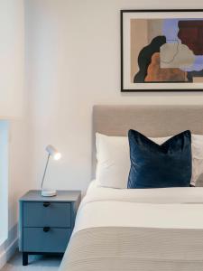 a bedroom with a bed with a blue nightstand and a picture at Urban Rest Camden Town in London