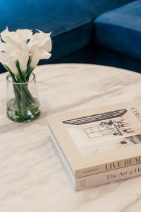 a book and a vase of flowers on a table at Urban Rest Camden Town in London +113 photos