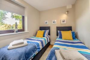 two beds in a room with a window at 2 Bed in Weybourne oc-2151 in Weybourne