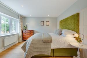 a bedroom with a large bed with a green headboard at 2 Bed in Beccles oc-rilo in Beccles