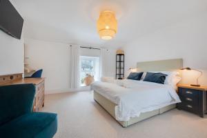 a white bedroom with a large bed and a couch at 2 Bed in Aberaeron oc-bow329 in Aberaeron