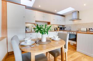 a kitchen with a wooden table with chairs and a vase at 1 Bed in Swannington oc-1011 in Alderford