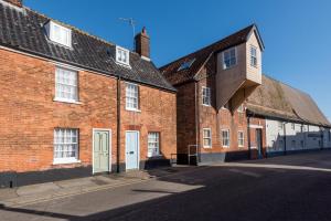 a brick building with white doors on a street at 4 Bed in Southwold oc-30vs in Southwold