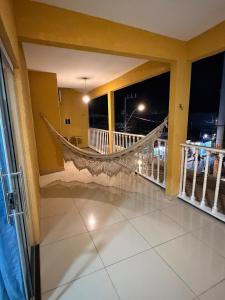 a room with a hammock on a balcony at night at Pipa House Center in Pipa