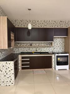 a kitchen with black cabinets and a white appliance at Pipa House Center in Pipa