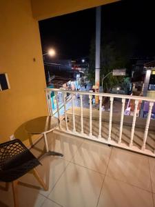 a balcony with a table and a chair and a view at Pipa House Center in Pipa +2 photos