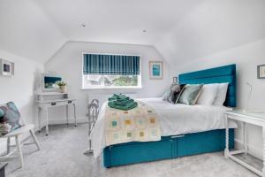 a bedroom with a blue bed and a desk at 4 Bed in Reydon oc-lxw in Reydon