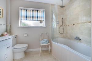 a bathroom with a tub and a toilet and a sink at 4 Bed in Reydon oc-lxw in Reydon +8 photos