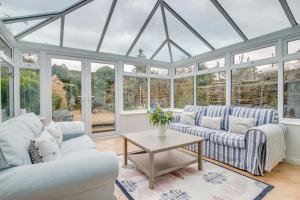 a conservatory with two couches and a table at 2 Bed in Woodbridge oc-g23 in Woodbridge +7 photos