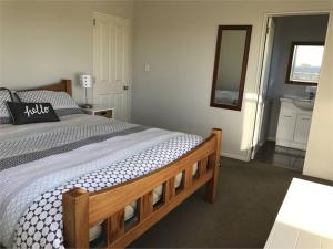 a bedroom with a wooden bed and a sink at Hydrabad Views in Waitarere