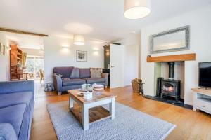 a living room with a blue couch and a fireplace at 3 Bed in Staplecross oc-rh1162 in Sedlescombe