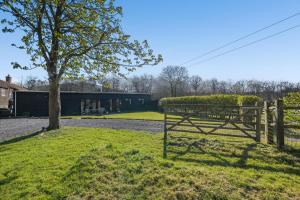 a fence next to a tree and a building at 3 Bed in Staplecross oc-rh1162 in Sedlescombe