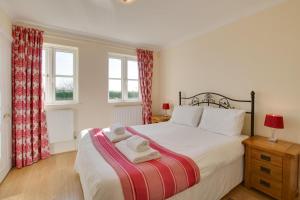 a bedroom with a bed with two towels on it at 4 Bed in Gower oc-hh9906 in Port-Eynon