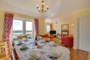 a dining room with a table and a living room at 4 Bed in Gower oc-hh9906 in Port-Eynon