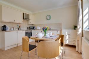 a kitchen with a table and chairs and a kitchen with white cabinets at 1 Bed in Tenterden oc-tn623 in Saint Michaels +9 photos