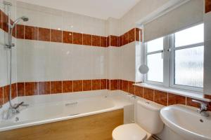 a bathroom with a tub and a toilet and a sink at 4 Bed in Gower oc-hh9906 in Port-Eynon +13 photos