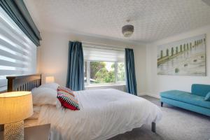 a bedroom with a bed and a blue couch at 3 Bed in Greatstone oc-ek777 in Littlestone-on-Sea