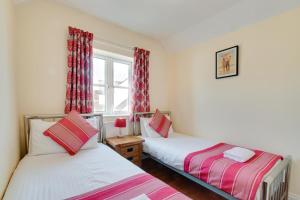 two beds in a room with a window at 4 Bed in Port Eynon oc-hh9905 in Port-Eynon