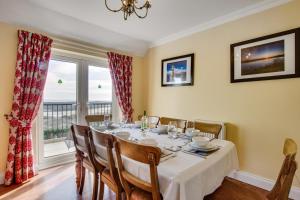 a dining room with a table and chairs and a window at 4 Bed in Port Eynon oc-hh9905 in Port-Eynon +12 photos