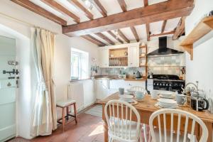 a kitchen with a wooden table with chairs and a stove at 2 Bed in East Runton oc-2034 in West Runton +11 photos