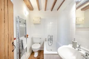 a white bathroom with a toilet and a sink at 2 Bed in East Runton oc-2034 in West Runton