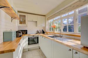 a kitchen with white cabinets and a sink at 2 Bed in Blakeney oc-1977 in Blakeney