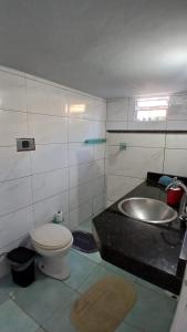 a bathroom with a toilet and a sink at Casa Rústica no centro de Araruama in Araruama +20 photos