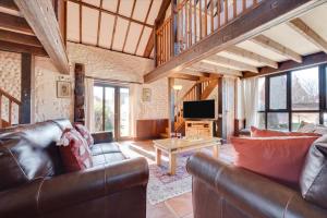a living room with a leather couch and a television at 2 Bed in Bacton oc-712 in Bacton
