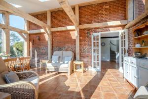 a living room with chairs and a brick wall at 2 Bed in Upton oc-867 in Upton