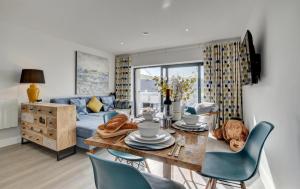a living room with a table and a blue couch at 3 Bed in Woolacombe oc-5byron in Woolacombe