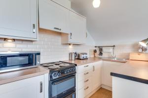 a kitchen with white cabinets and a stove top oven at 1 Bed in Mortehoe oc-barri in Mortehoe