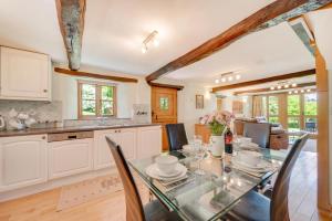 a kitchen and dining room with a glass table and chairs at 2 Bed in Meshaw oc-meadow in Meshaw