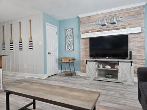 a living room with a flat screen tv on a wall at Seaside Gem in Biloxi