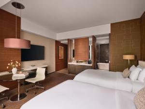 a hotel room with a large bed and a desk at The Langham, Shanghai, Xintiandi in Shanghai